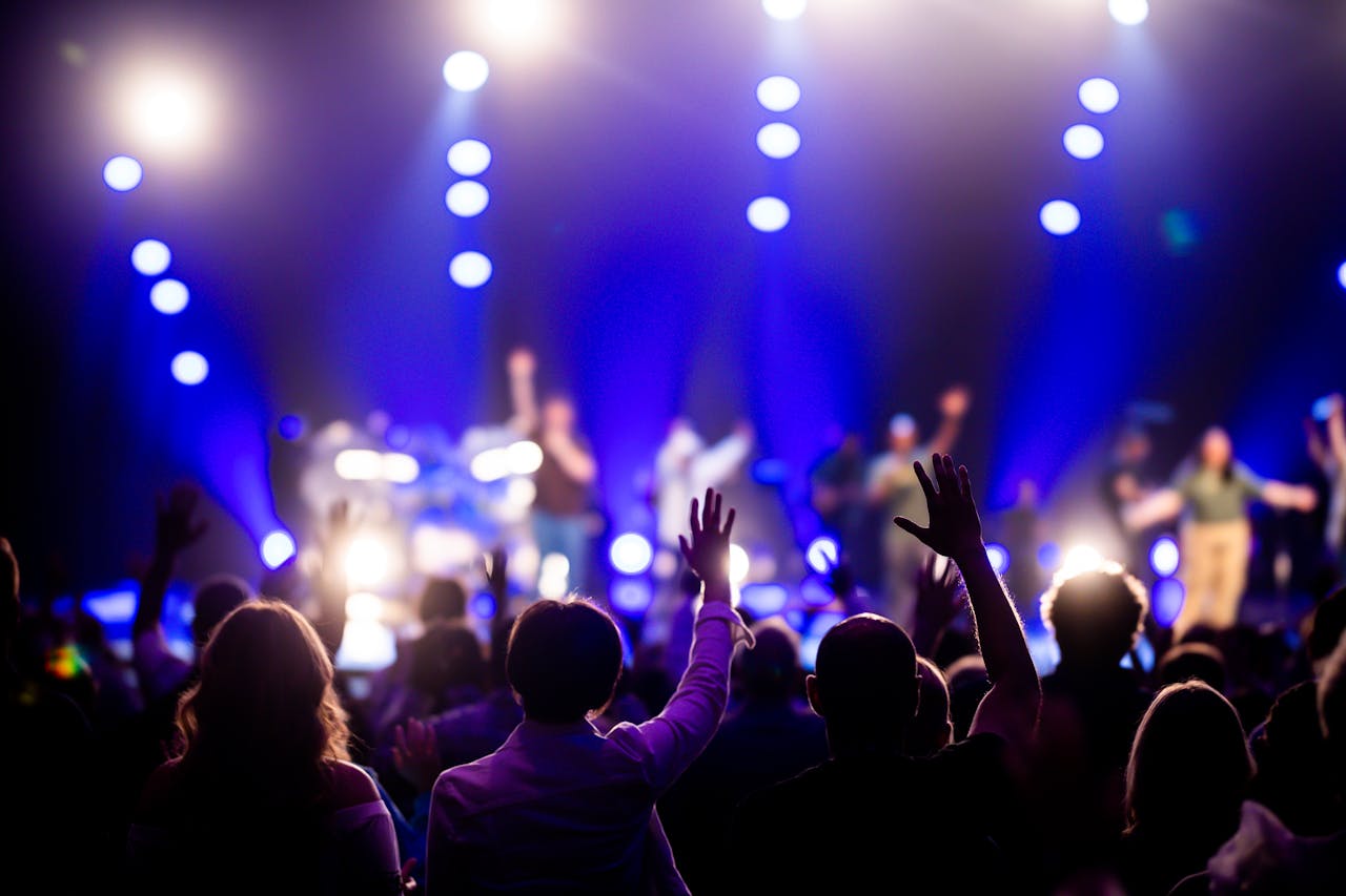 who-we-are A vibrant concert scene with an engaged audience enjoying live music under dramatic lighting.